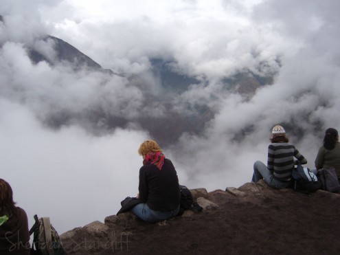 Tourists sitting on terraces on Huayna Picchu looking over Machu Picchu, Peru